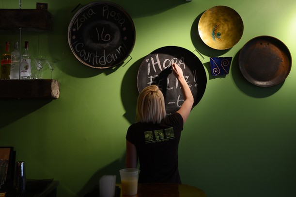 Isalita bartender Billi Bowman freshens up a chalkboard near the bar.  Melanie Maxwell I AnnArbor.com